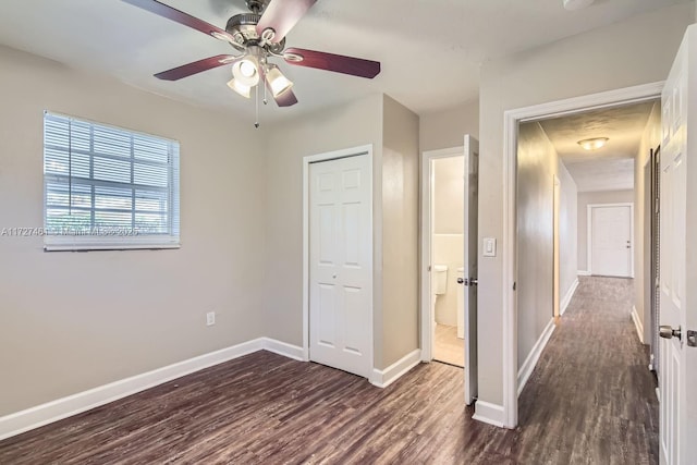 unfurnished bedroom with dark wood-type flooring, ceiling fan, and a closet