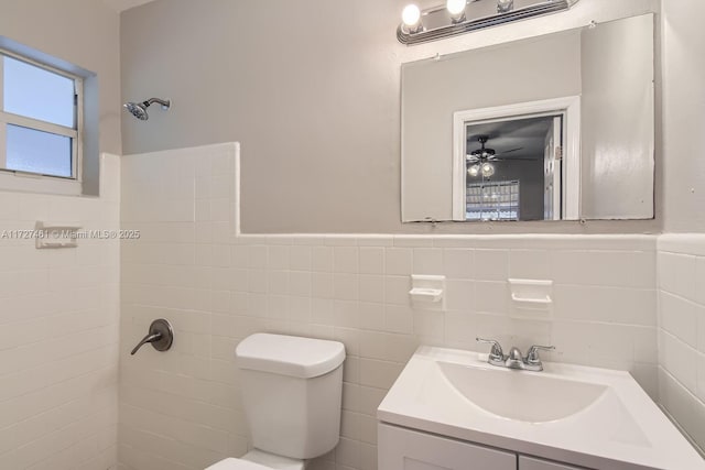 bathroom featuring vanity, tile walls, and toilet