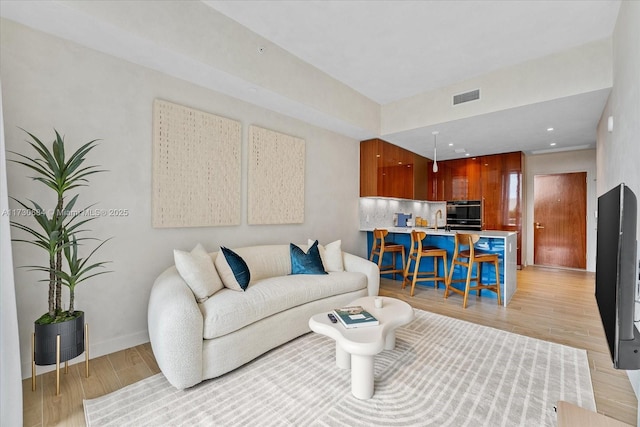 living room with sink and light hardwood / wood-style floors