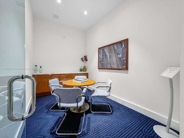 dining space featuring dark colored carpet