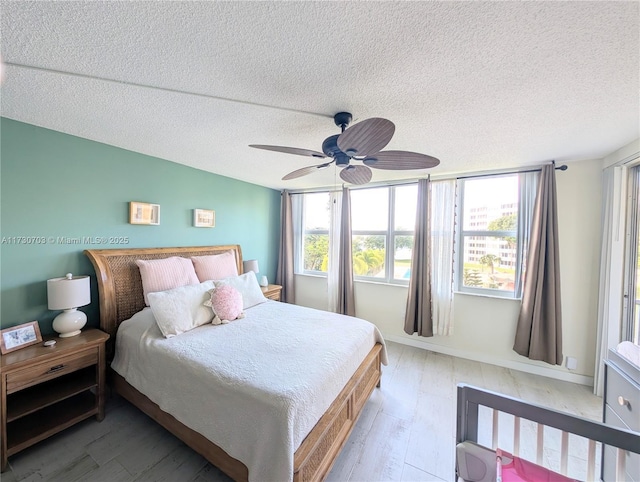 bedroom with hardwood / wood-style floors, a textured ceiling, and ceiling fan