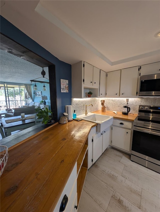 kitchen featuring wood counters, sink, white cabinets, and appliances with stainless steel finishes