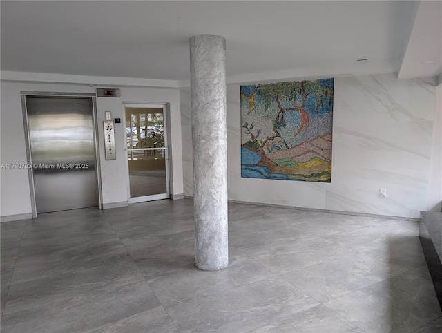 hallway with elevator and decorative columns