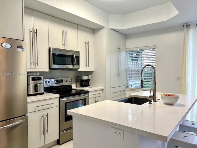 kitchen with sink, a center island with sink, tasteful backsplash, and appliances with stainless steel finishes