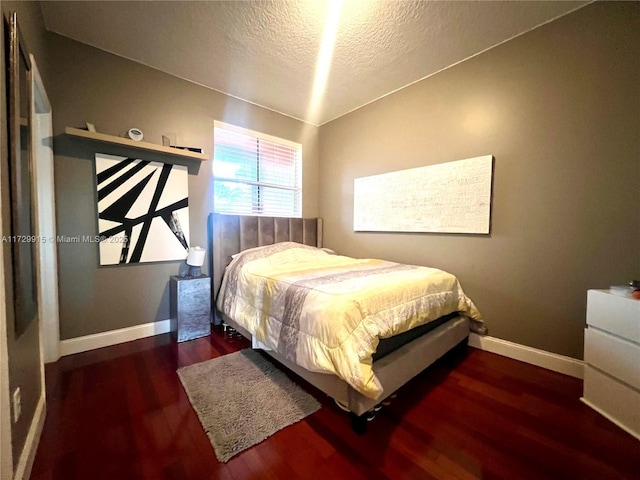 bedroom featuring dark wood-type flooring and a textured ceiling