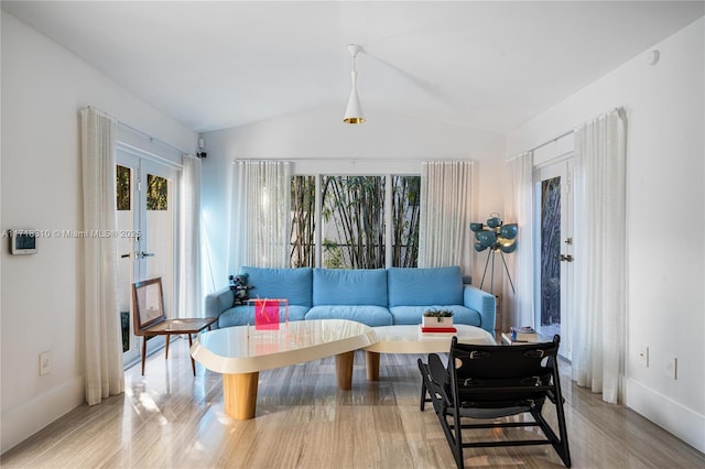 living room with french doors, hardwood / wood-style floors, and lofted ceiling