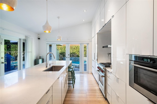 kitchen featuring pendant lighting, white cabinets, stainless steel appliances, french doors, and sink