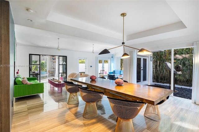 dining room featuring a tray ceiling and french doors