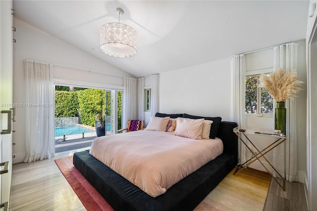 bedroom with light hardwood / wood-style floors, access to exterior, lofted ceiling, and a chandelier