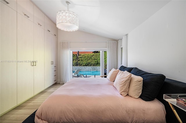 bedroom with access to exterior, light hardwood / wood-style floors, and lofted ceiling