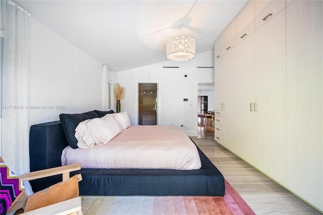 bedroom featuring light hardwood / wood-style flooring and lofted ceiling