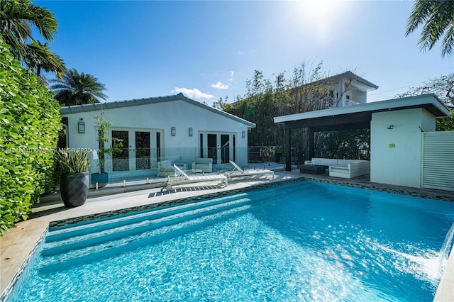 view of swimming pool with a patio area, french doors, and an outdoor structure