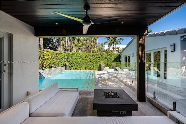 view of patio with ceiling fan, an outdoor fire pit, and a fenced in pool