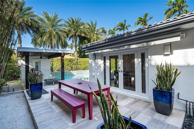 view of patio / terrace with a wooden deck, ceiling fan, and french doors