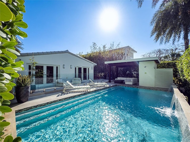 view of pool featuring an outdoor living space, a patio, an outbuilding, pool water feature, and french doors