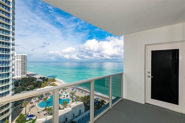 balcony with a water view and a view of the beach