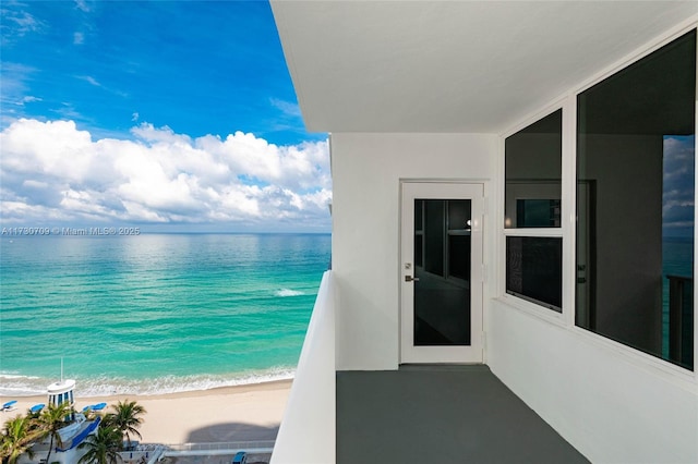 balcony with a water view and a beach view