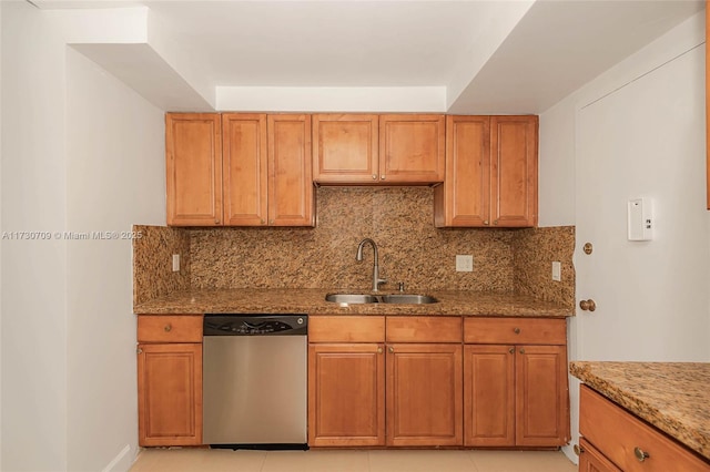 kitchen featuring sink, light stone countertops, light tile patterned floors, and stainless steel dishwasher