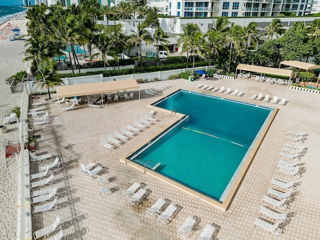 view of pool featuring a water view and a patio area