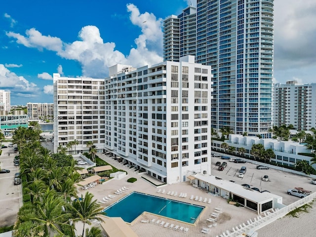 view of building exterior featuring a community pool and a view of city