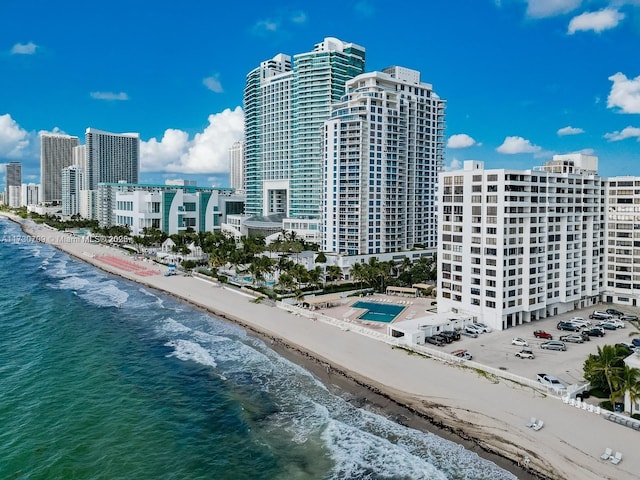 view of building exterior featuring a water view and a beach view