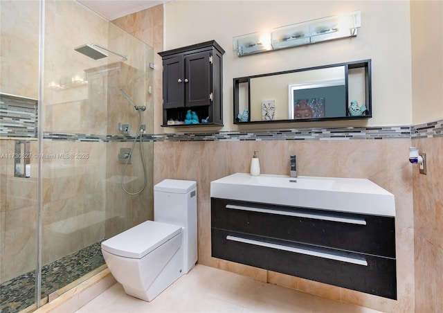 bathroom with toilet, an enclosed shower, tile walls, tile patterned floors, and vanity