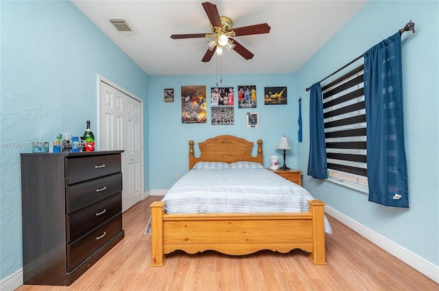 bedroom featuring ceiling fan, a closet, and light wood-type flooring