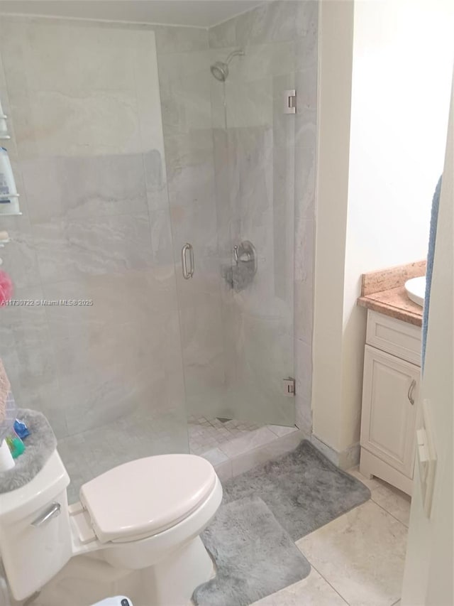 bathroom with tile patterned floors, an enclosed shower, vanity, and toilet