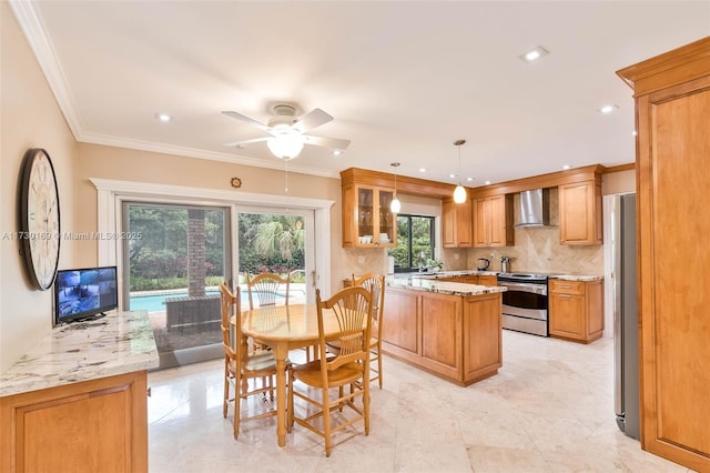 kitchen with appliances with stainless steel finishes, decorative light fixtures, decorative backsplash, a healthy amount of sunlight, and wall chimney range hood