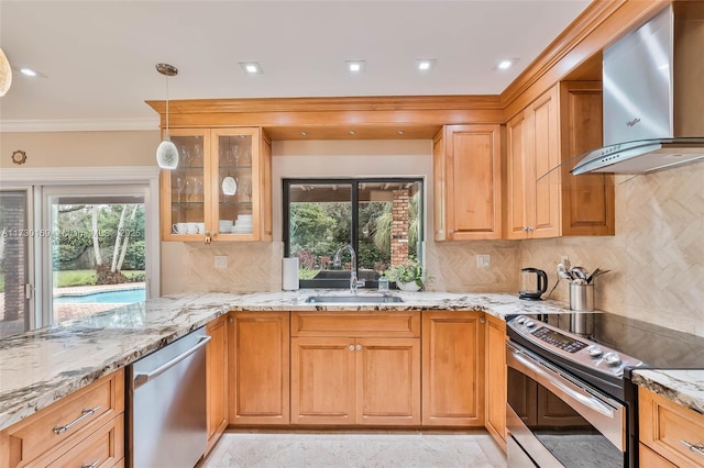 kitchen featuring wall chimney range hood, sink, stainless steel appliances, tasteful backsplash, and light stone countertops