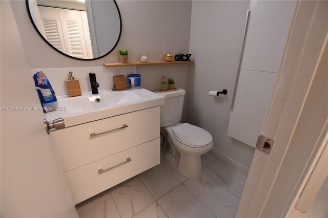 bathroom with vanity, tasteful backsplash, and toilet