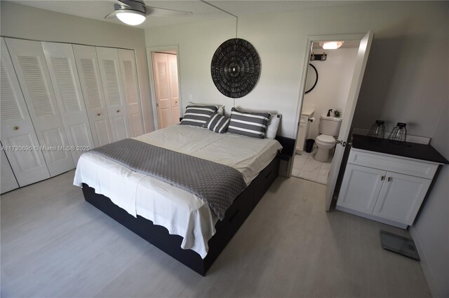 bedroom with two closets, ceiling fan, and ensuite bathroom