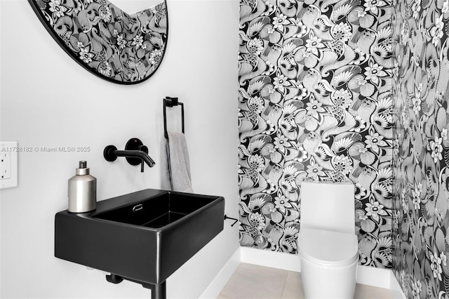 bathroom with sink, toilet, and tile patterned flooring