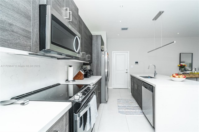 kitchen with sink, pendant lighting, light tile patterned floors, and stainless steel appliances