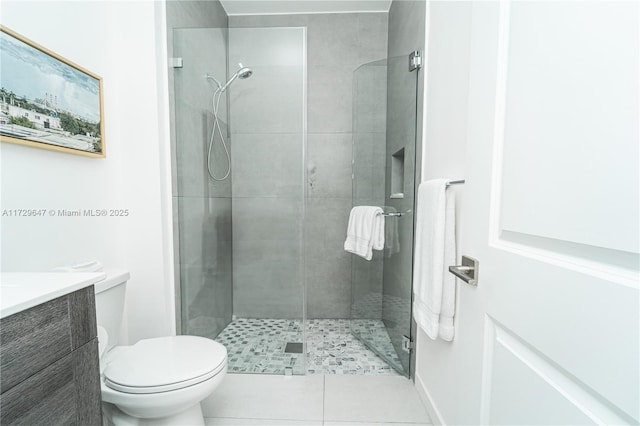 bathroom with a shower with shower door, toilet, vanity, and tile patterned flooring