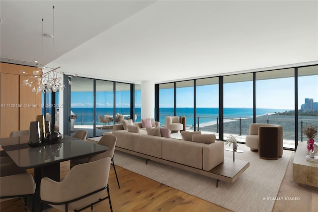 living room featuring a chandelier, light hardwood / wood-style flooring, and a water view