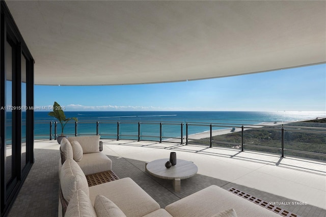 balcony with a water view, outdoor lounge area, and a view of the beach