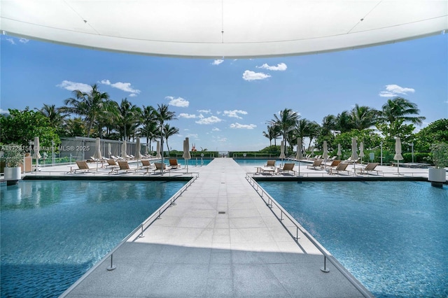 view of pool with a water view and a patio area