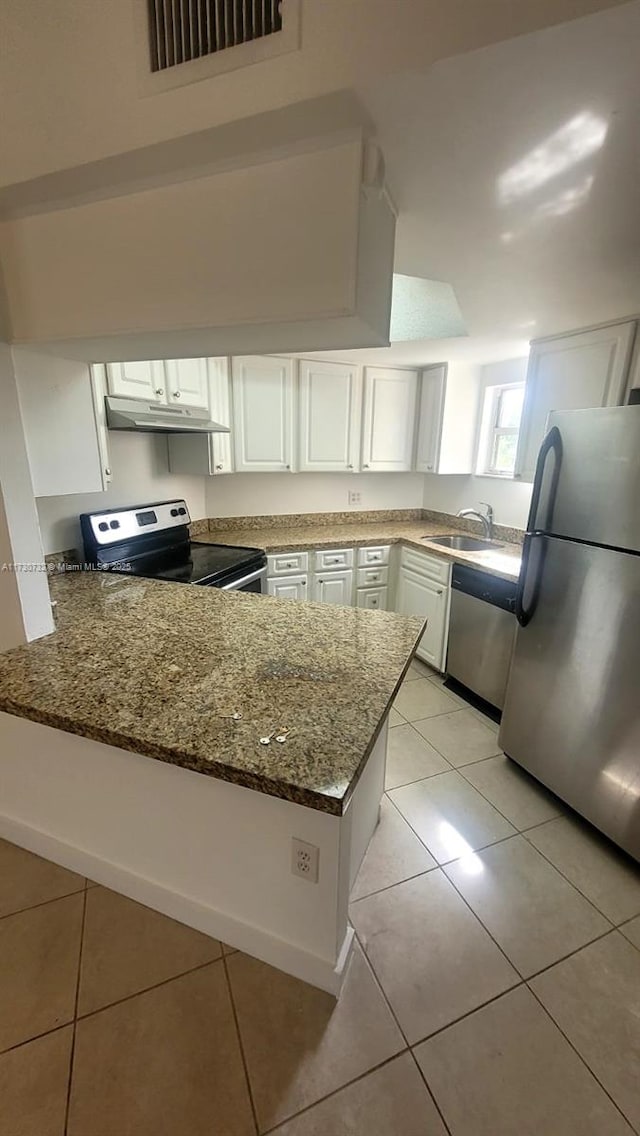 kitchen featuring white cabinetry, stainless steel appliances, dark stone countertops, sink, and kitchen peninsula