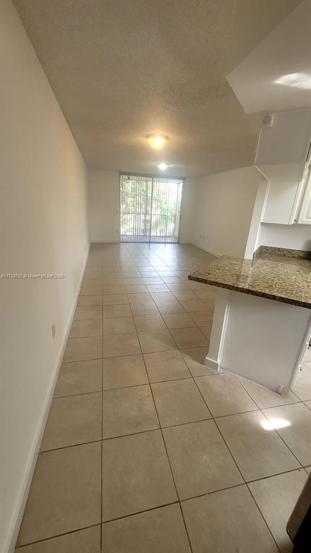 unfurnished room featuring a textured ceiling and light tile patterned flooring