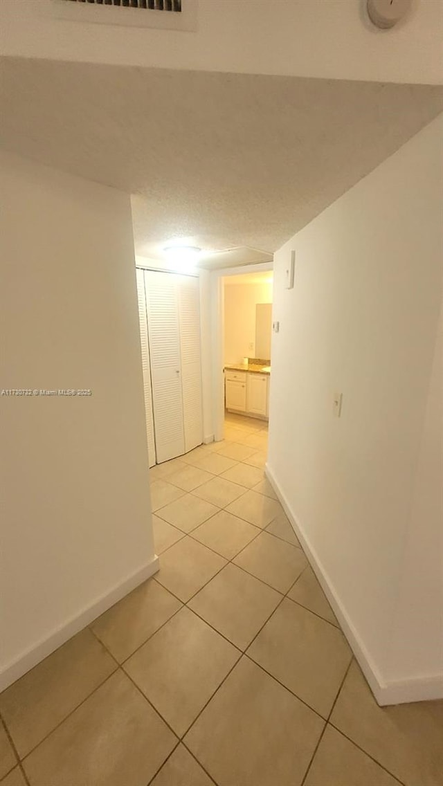 hall with light tile patterned floors