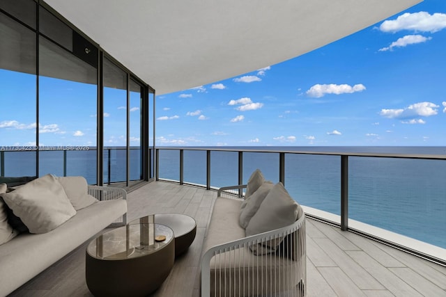 balcony featuring outdoor lounge area and a water view