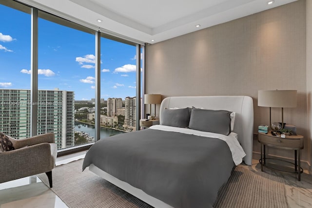 bedroom with a water view and a wall of windows