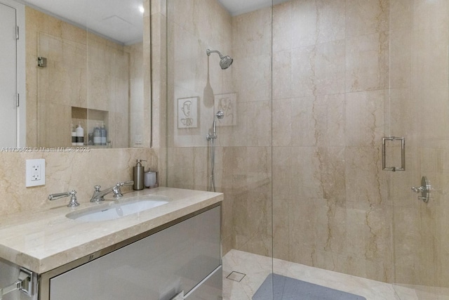 bathroom featuring walk in shower, vanity, and tasteful backsplash