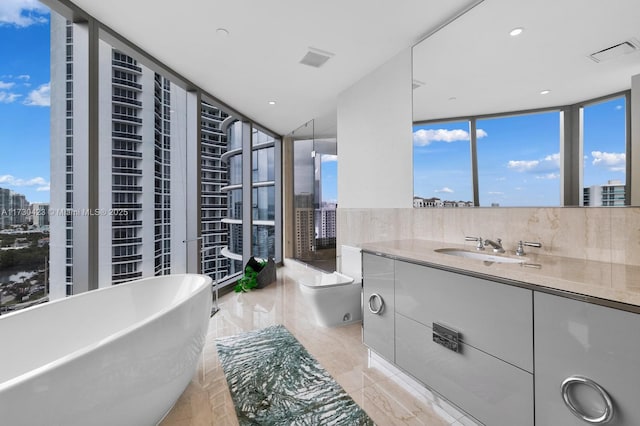 bathroom with vanity, toilet, backsplash, and a tub to relax in