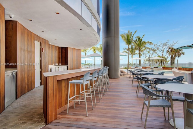 wooden deck featuring a water view and an outdoor bar