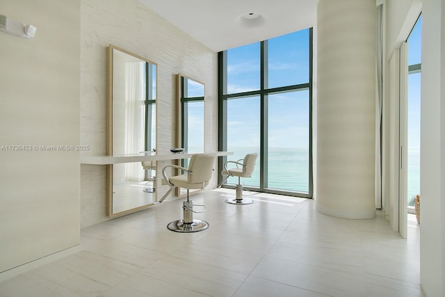 hallway with a water view and a wall of windows