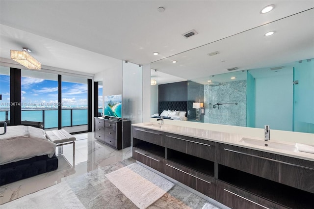 bathroom with tiled shower, expansive windows, and vanity