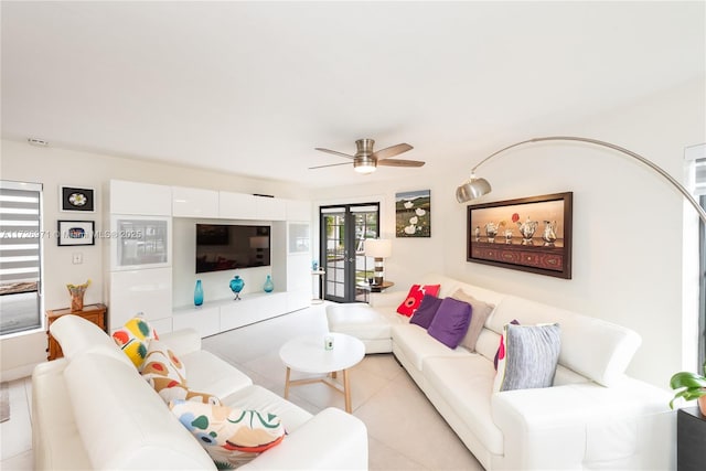 tiled living room with ceiling fan and french doors