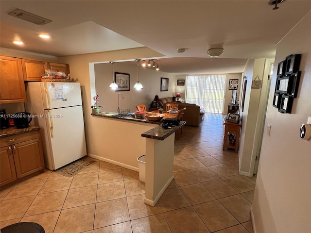 3300 W Rolling Hills Cir Unit 102, Davie, FL 33328 - kitchen with freestanding refrigerator, a peninsula, light tile patterned floors, open floor plan, and decorative light fixtures